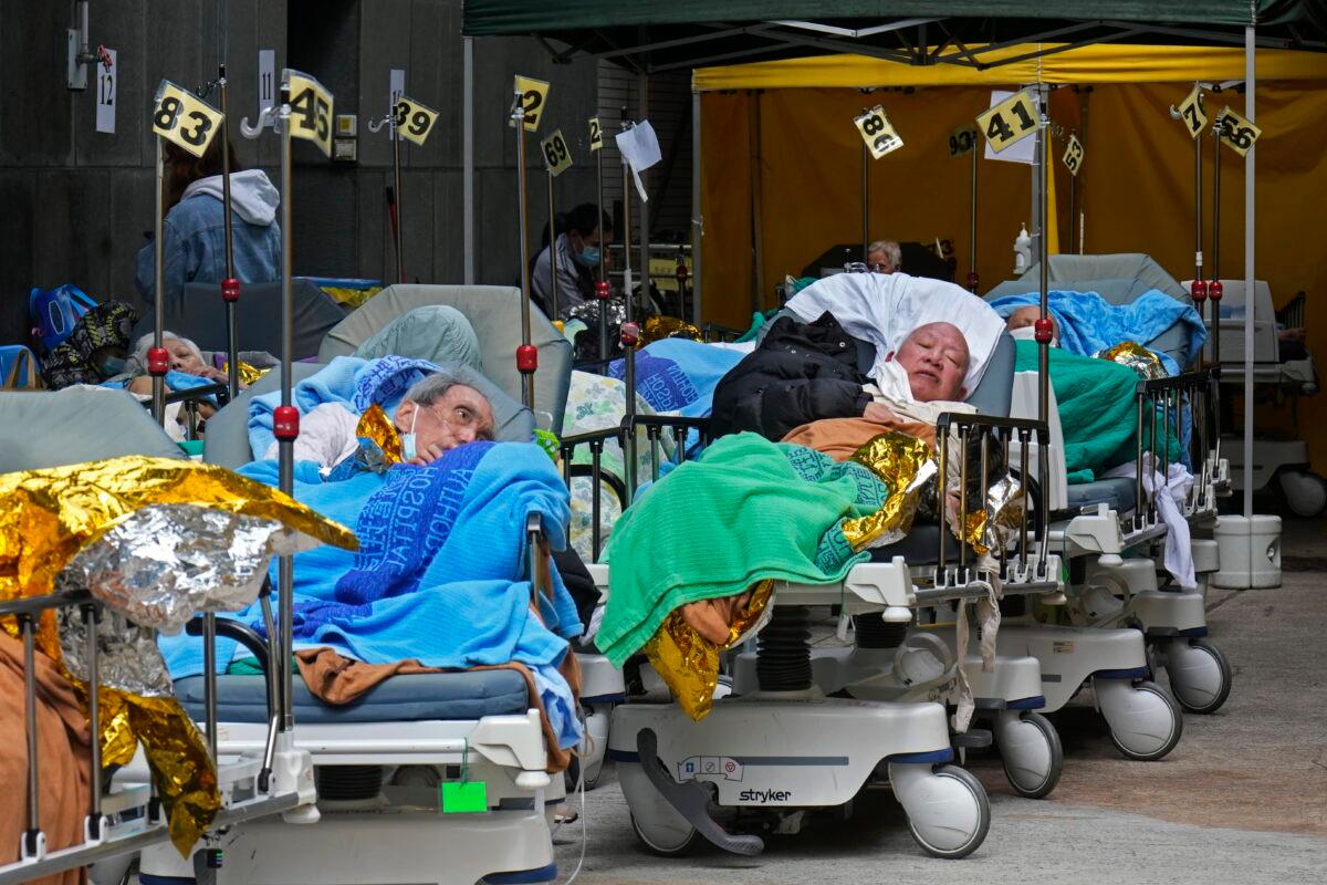Patients lie on hospital beds as they wait at a temporary holding area outside Caritas Medical Centre in Hong Kong on Feb. 16, 2022. (Vincent Yu/AP Photo)