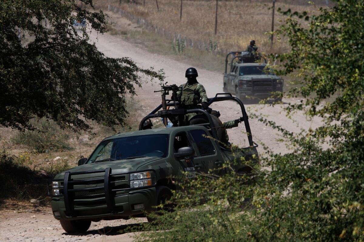 Mexican soldiers patrol near Naranjo de Chila in the municipality of Aguililla, Mexico, on Feb. 18, 2022. The town was the scene of a bloody turf battle between two drug cartels. (Armando Solis/AP Photo)