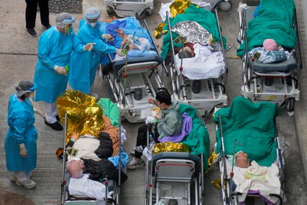 Patients lie on hospital beds at a temporary holding area outside Caritas Medical Center in Hong Kong on Feb. 16, 2022. (Vincent Yu/AP Photo)