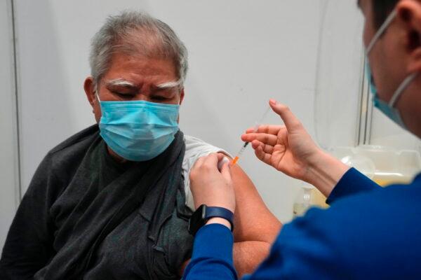 Hui Ngai-seng, 75, receives his first dose of China's Sinovac COVID-19 coronavirus vaccine at a community vaccination center in Hong Kong, Friday, Feb. 25, 2022. (AP Photo/Kin Cheung)