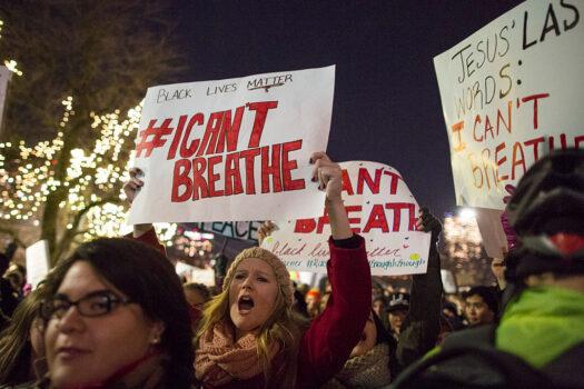In a file photo, protesters march while chanting and holding signs during a protest against the decision by a Staten Island grand jury to not indict a police officer who used a chokehold in the death of Eric Garner in July 2014 on Dec. 4, 2014, in Boston. (Scott Eisen/Getty Images)
