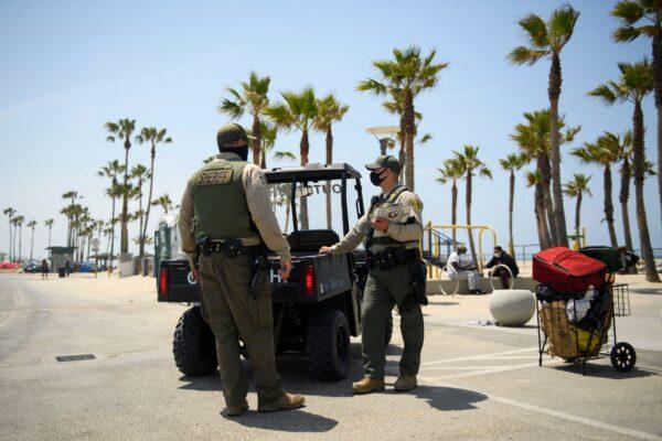 Los Angeles Sheriff's Department deputies take part in efforts to connect homeless people with housing in order to clear the boardwalk of encampments at Venice Beach on June 16, 2021. (Patrick T. Fallon/AFP via Getty Images)