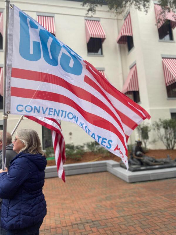 A Convention of States supporter holds the COS Action flag at the Rally in Tally on Feb. 8, 2022. (Brenna Rummel)