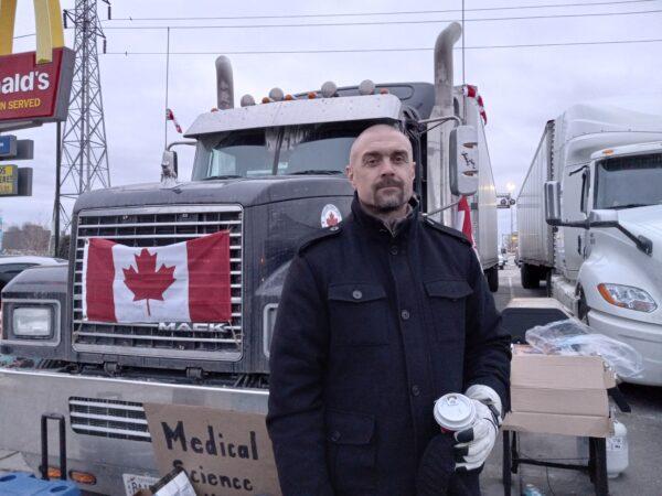 Truck driver Kade Dubai takes part in the blockade by the Ambassador Bridge in Windsor, Ontario, on Feb. 10, 2022. (Lisa Lin/The Epoch Times)