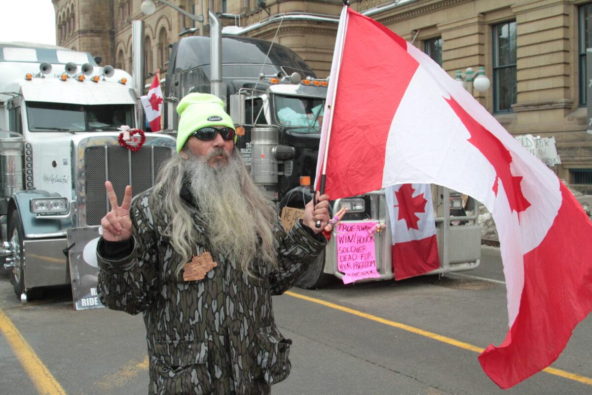 Dana-Lee Melfi says the Ottawa protest is a peaceful one and it is his role to let everyone know that. He stands at the front of the line of trucks with his hand making the peace sign for 10 hours a day. (Richard Moore/The Epoch Times)