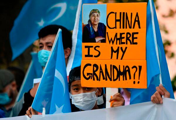 A young Uyghur activist holds up a poster that reads "China where is my grandma?!" during a demonstration outside the Foreign Office in Berlin, where the Chinese Foreign Minister was expected to hold talks with his German counterpart, on Sept. 1, 2020. (Tobias Schwarz/AFP via Getty Images)