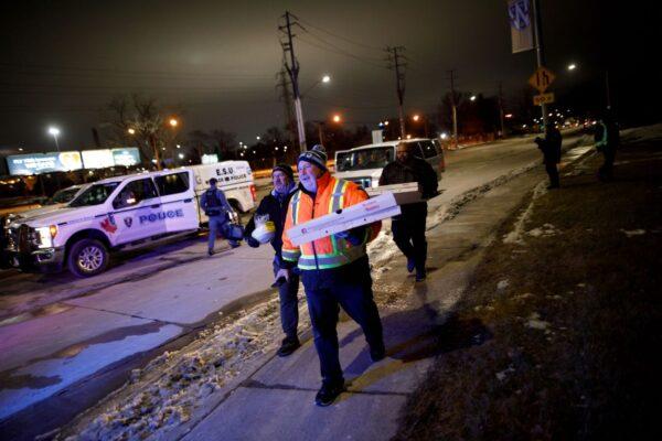 Protestors and supporters bring pizza to protestors as they attend a blockade at the foot of the Ambassador Bridge, sealing off the flow of commercial traffic over the bridge into Canada from Detroit, in Windsor, Ontario, on Feb. 10, 2022. (Cole Burston/Getty Images)