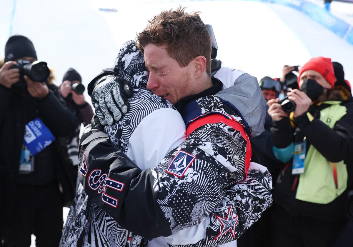 Shaun White of Team United States embraces their coach JJ Thomas after finishing fourth during the Men's Snowboard Halfpipe Final on day 7 of the Beijing 2022 Winter Olympics at Genting Snow Park, in Zhangjiakou, China, on Feb. 11, 2022. (Maddie Meyer/Getty Images)