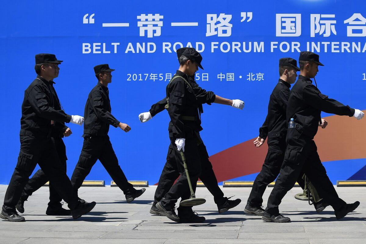 Security guards walk past a billboard for the Belt and Road Forum for International Cooperation at the forum's venue in Beijing on May 13, 2017. (Wang Zhao/AFP via Getty Images)