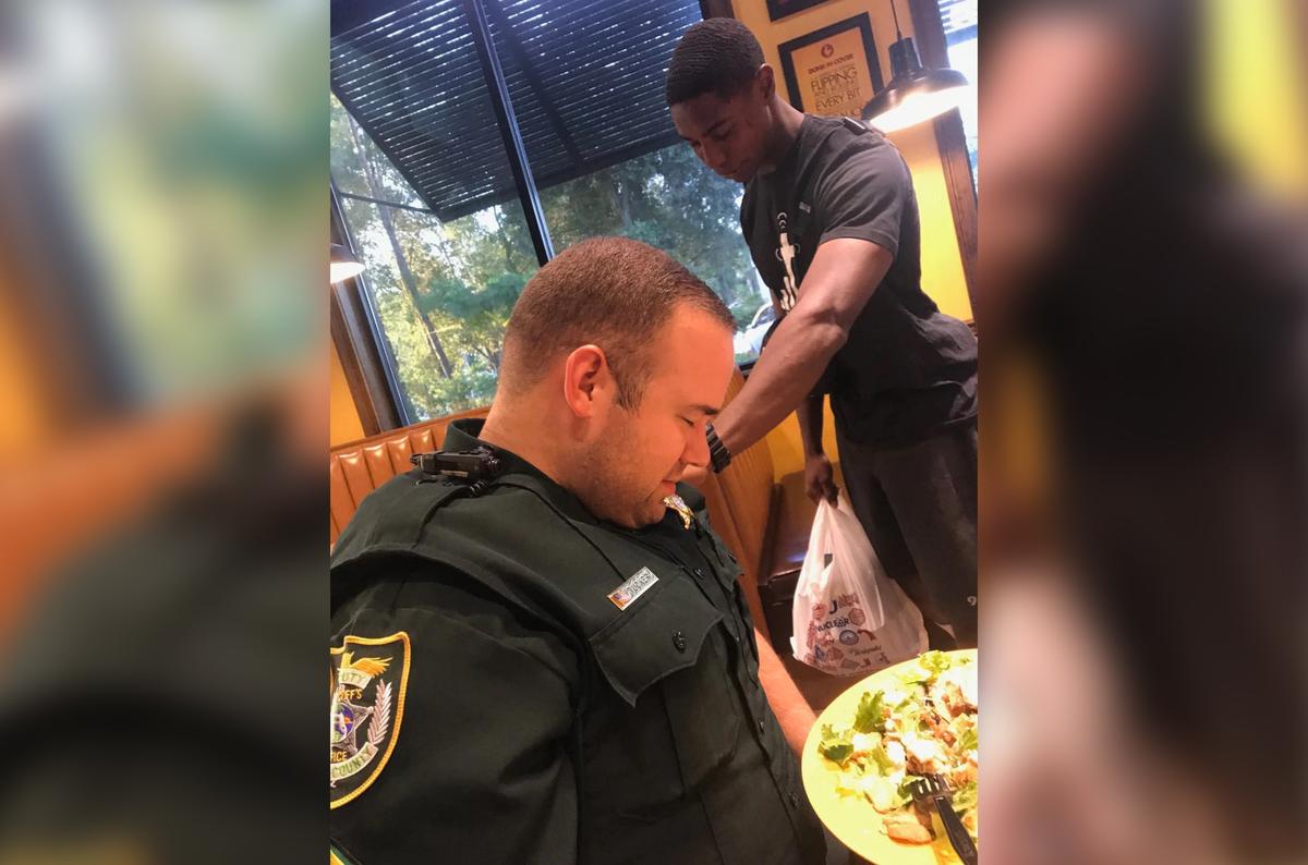 A photo showing Juan O'Neal praying for Deputy Tucker in a DeLand, Florida, Zaxby's went viral in 2019. (Courtesy of <a href="https://www.volusiasheriff.org/">Volusia Sheriff's Office</a>)