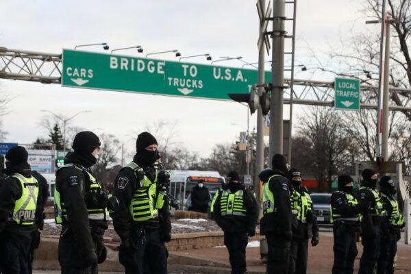 Police officers stand guard on a street as truckers and supporters continue blocking access to the Ambassador Bridge, which connects Detroit and Windsor, in protest against COVID-19 mandates and restrictions, in Windsor, Ont., on Feb. 12, 2022. (Reuters/Carlos Osorio)