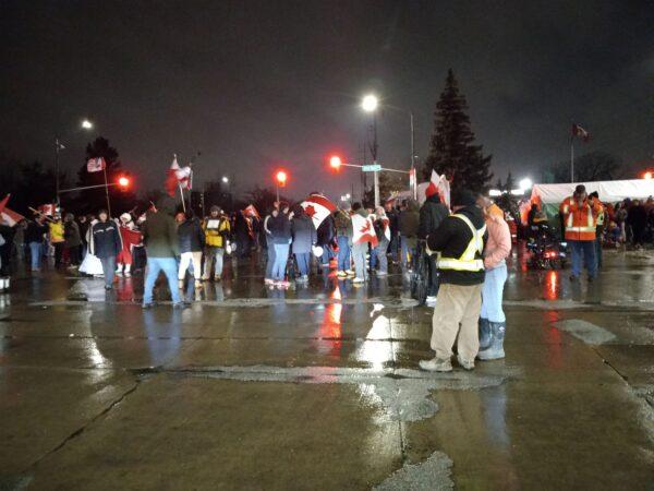 Protesters gather at the Canada-U.S. border crossing in Windsor on the evening of Feb. 11, 2022. (Lisa Lin/The Epoch Times)