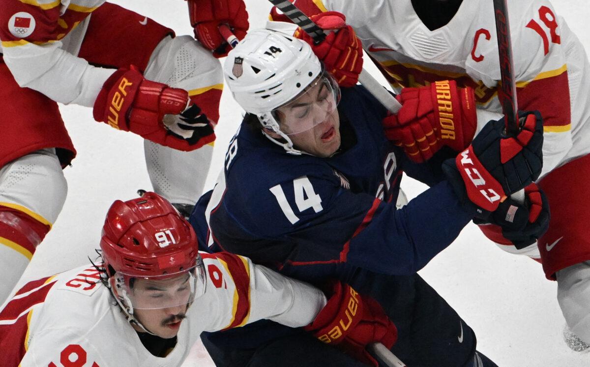 United States team player Brock Faber (C) vies with China's Tyler Wong (L), Zhang Zesen (top), and Brandon Yip during their men's preliminary round group A match of the Beijing 2022 Winter Olympic Games ice hockey competition, at the National Indoor Stadium in Beijing on Feb. 10, 2022. (Anthony Wallace/AFP via Getty Images)