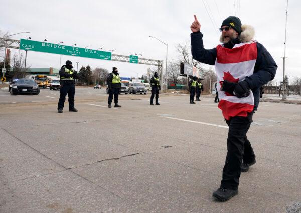 A protester yells at police as they deploy to move demonstrators blocking access to the Ambassador Bridge in Windsor, Ont., on Feb. 12, 2022. (Geoff Robins/AFP via Getty Images)