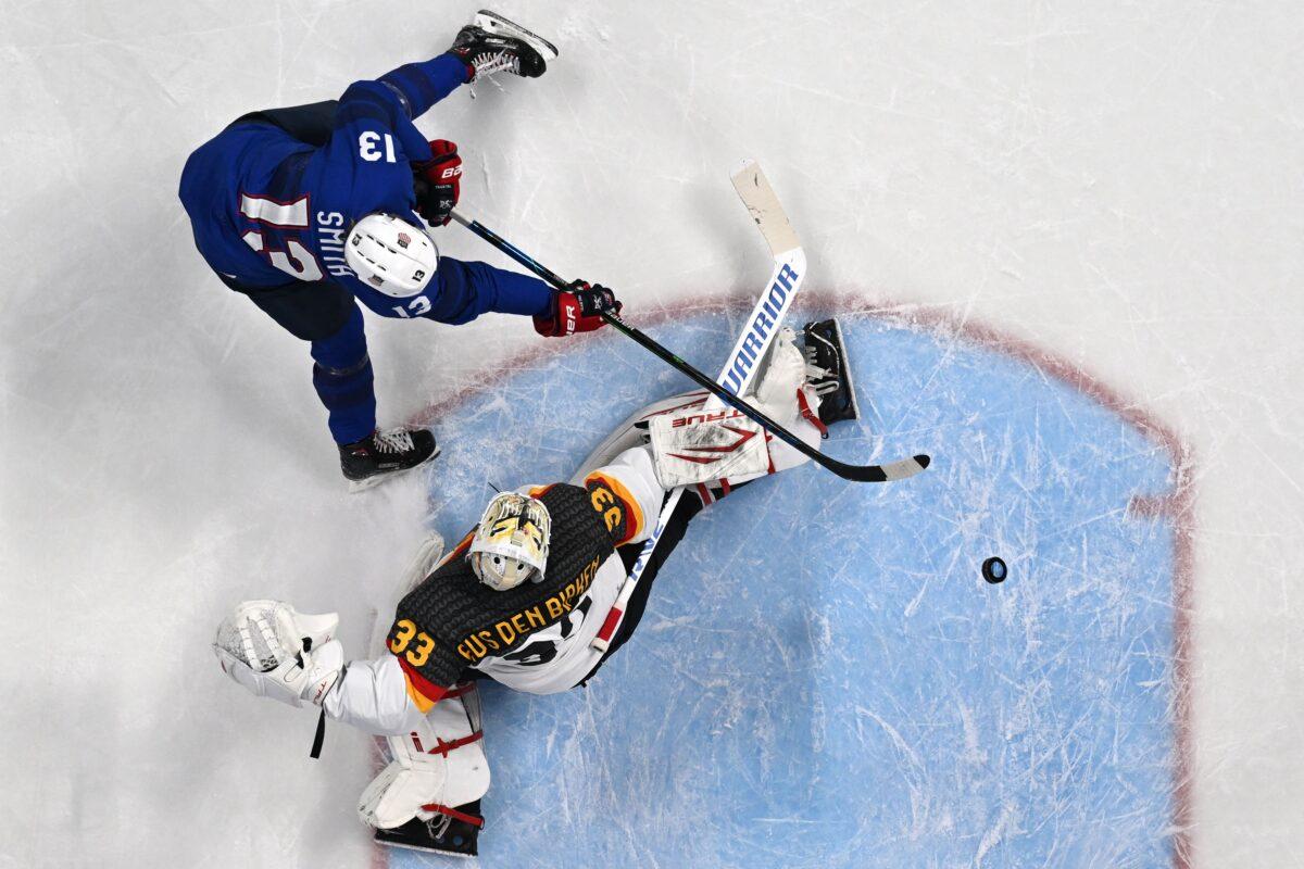 USA's Nathan Smith (Top) challenges Germany's goaltender Danny aus den Birken during the men's preliminary round group A match of the Beijing 2022 Winter Olympic Games ice hockey competition between USA and Germany, at the Wukesong Sports Centre, in Beijing, on Feb. 13, 2022. (Anthony Wallace/AFP via Getty Images)
