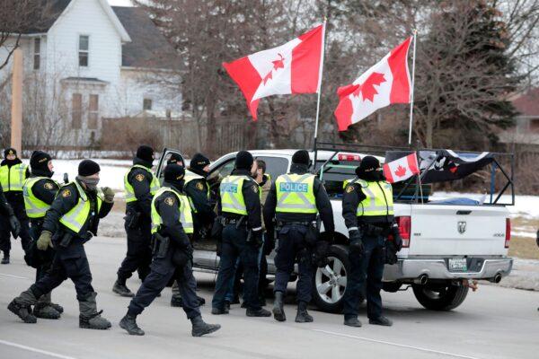Police surround a pickup truck as they clear protestors at the Ambassador Bridge in Windsor, Ont., on Feb. 13, 2022. (Jeff Kowalsky/AFP via Getty Images)