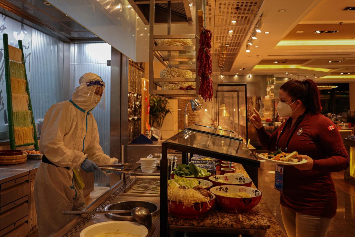 A worker in a hazmat suits works in a hotel restaurant buffet section, which is part of the closed-loop Winter Olympics Accommodation Allocation Agreement (AAA) in Beijing, China, on Feb. 10, 2022. (Annice Lyn/Getty Images)