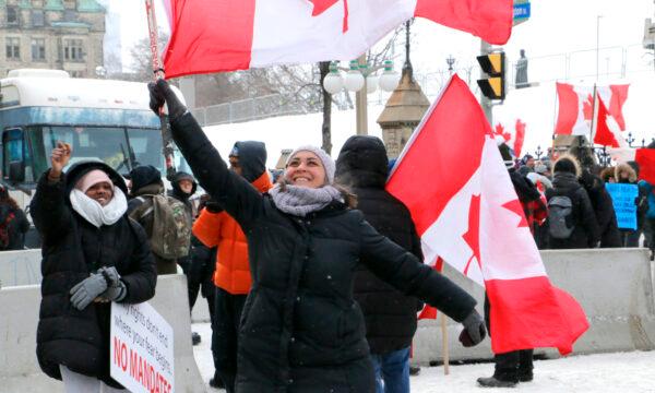 A protester dances and waves a Canadian flag in Ottawa on Feb. 12, 2022. (Noé Chartier/The Epoch Times)