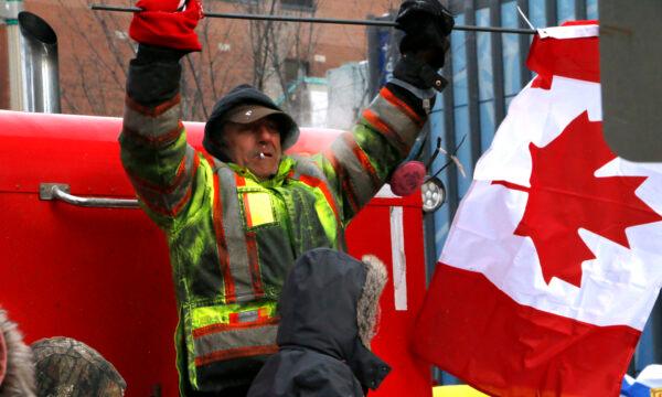 A protester dances and holds a Canadian flag at one of the dance parties in Ottawa on Feb. 12, 2022. (Noé Chartier/The Epoch Times)