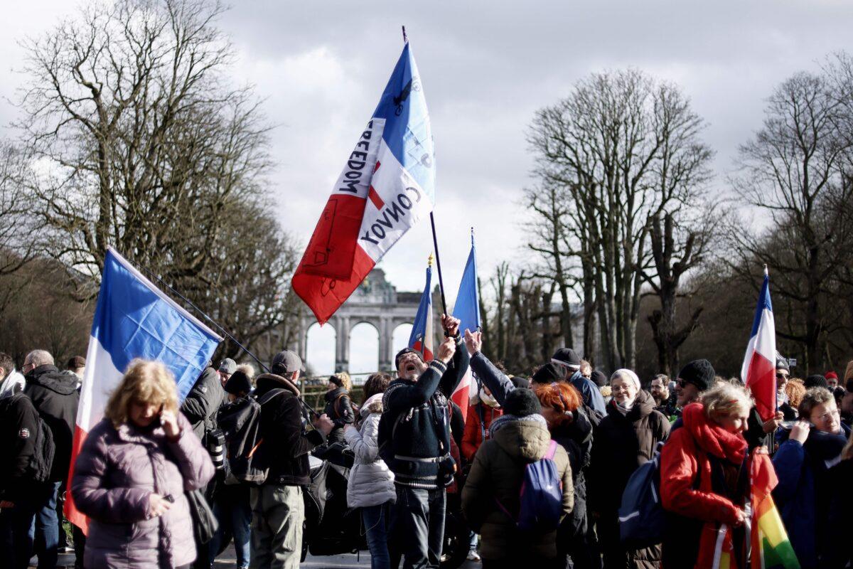 Participants in the so-called "Freedom Convoy" wave French flags as they gather for an unauthorized demonstration in the center of Brussels, Belgium, on Feb. 14, 2022. (Kenzo Tribouillard/AFP via Getty Images)