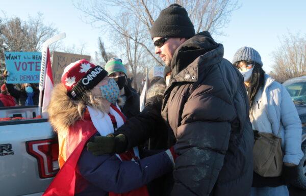 An altercation after a man is hit with a placard during the attempt by counterprotesters to trap 20 vehicles belonging to protesters in Ottawa on Feb. 13, 2022. (Richard Moore/The Epoch Times)