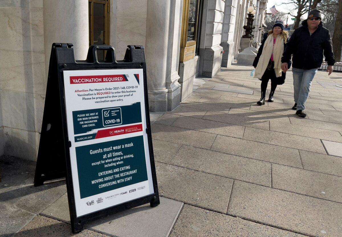 A sign requiring proof of vaccination for guests is posted outside of a restaurant in downtown Washington on Jan. 19, 2022. (Daniel Slim/AFP via Getty Images)