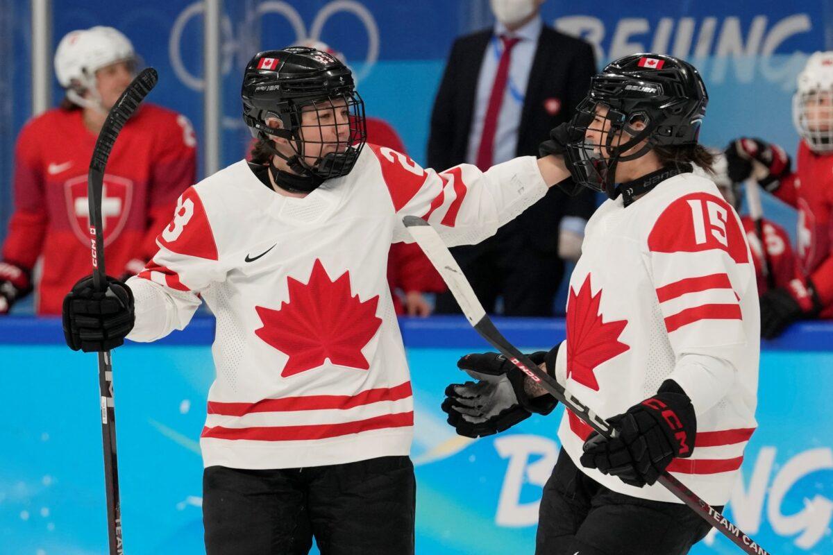 Canada's Erin Ambrose (23) and Melodie Daoust (15) celebrate after Ambrose scored a goal against Switzerland during a women's semifinal hockey game at the 2022 Winter Olympics in Beijing, on Feb. 14, 2022. (Petr David Josek/AP Photo)