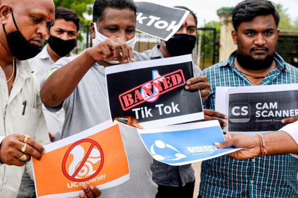 Members of the City Youth Organization hold posters with the logos of Chinese apps in support of the Indian government for banning the wildly popular video-sharing TikTok app, in Hyderabad, India, on June 30, 2020. India banned another 54 Chinese apps in February 2022. (Noah Seelam/AFP via Getty Images)