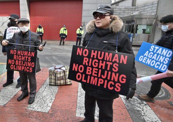 Protesters hold placards linking China's human rights record and the ongoing Beijing Winter Olympic Games during a rally in front of the Chinese embassy in Seoul, South Korea, on Feb. 9, 2022. (Jung Yeon-je/AFP via Getty Images)