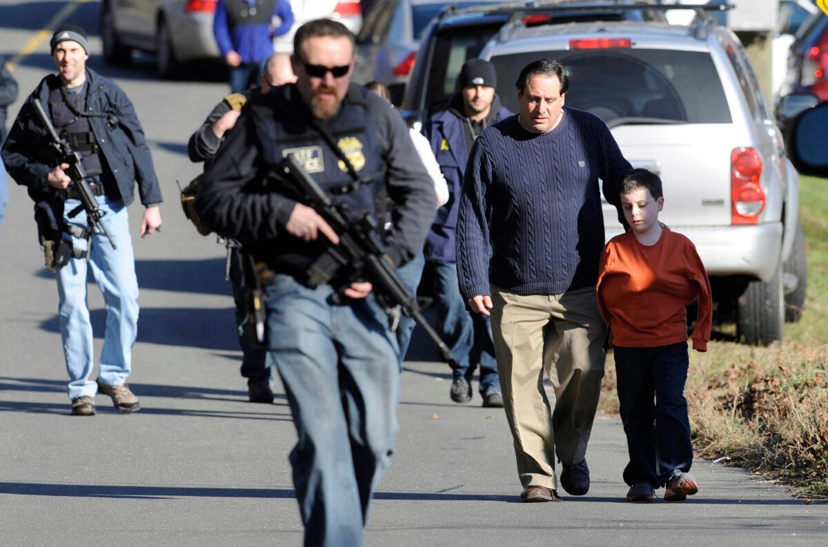 Parents leave a staging area after being reunited with their children following the shooting at the Sandy Hook Elementary School in Newtown, Conn., on Dec. 14, 2012. (Jessica Hill/AP Photo)