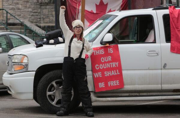 A protester signals no surrender in downtown Ottawa on Feb. 13, 2022. (Richard Moore/The Epoch Times)