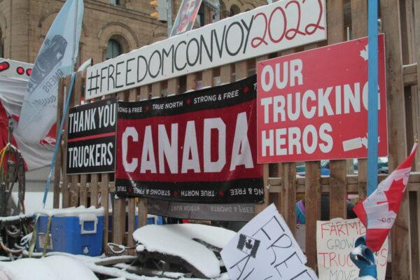 Signs supporting the Freedom Convoy 2022 adorn fences along Wellington St in the centre of Ottawa on Feb. 12, 2022. (Richard Moore/The Epoch Times)