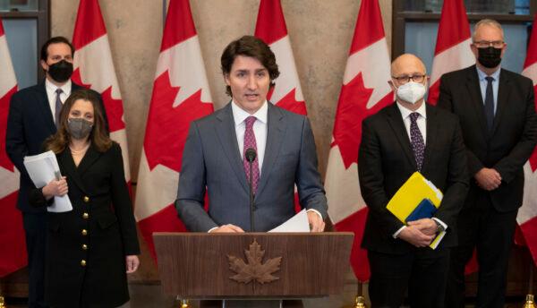 (L–R) Public Safety Minister Marco Mendicino, Deputy Prime Minister and Finance Minister Chrystia Freeland, Justice Minister and Attorney General of Canada David Lametti, and President of the Queen's Privy Council for Canada and Emergency Preparedness Minister Bill Blair stand behind Canada's Prime Minister Justin Trudeau as he announces the Emergencies Act will be invoked to deal with protests, in Ottawa on Feb. 14, 2022. (Hailey Sani/Public Domain)