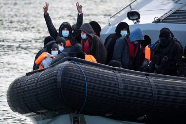 Illegal immigrants react onboard UK Border Force vessel HMC Speedwell after being picked up at sea, as they are brought into the Marina in Dover, southeast England, on Dec. 21, 2021. (Ben Stansall/AFP via Getty Images)