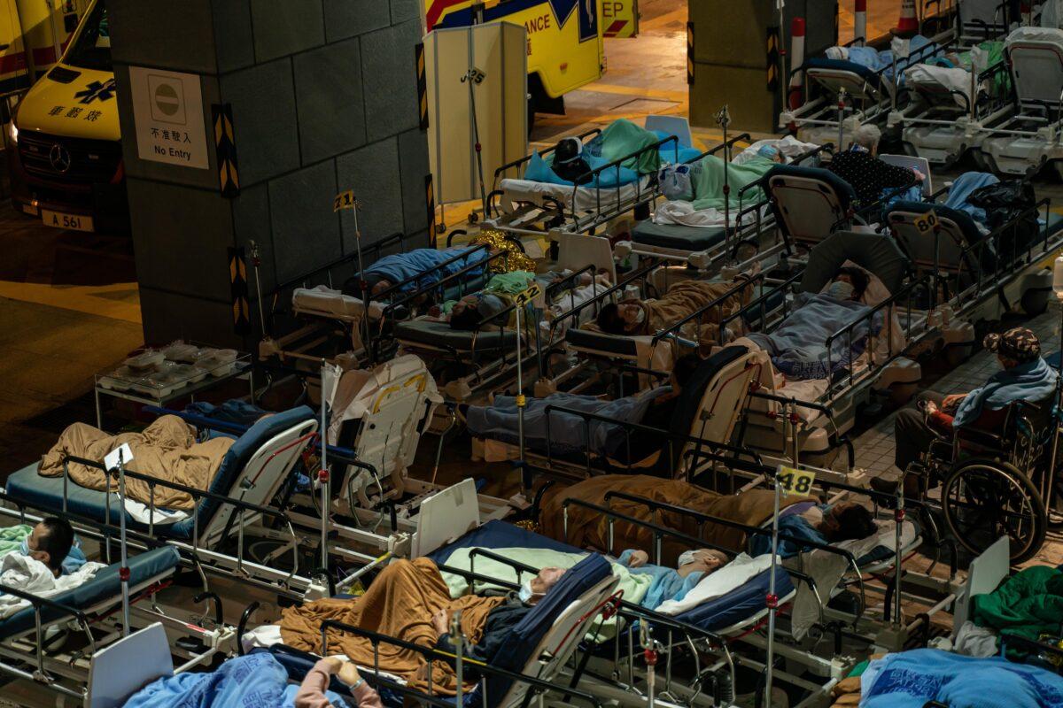 Patients lay in beds as they wait at a temporary holding area outside Caritas Medical Centre in Hong Kong on Feb. 16, 2022. (Anthony Kwan/Getty Images)