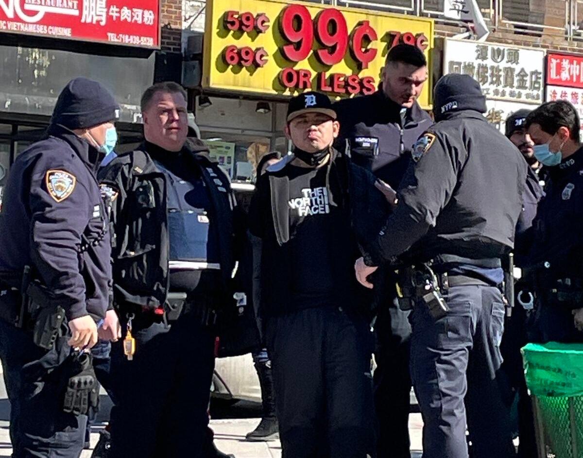 Police arrest Zheng Buqiu for attacking information booths operated by Falun Gong practitioners, in Flushing, N.Y., on Feb. 15, 2022. (Provided by Falun Gong practitioners)