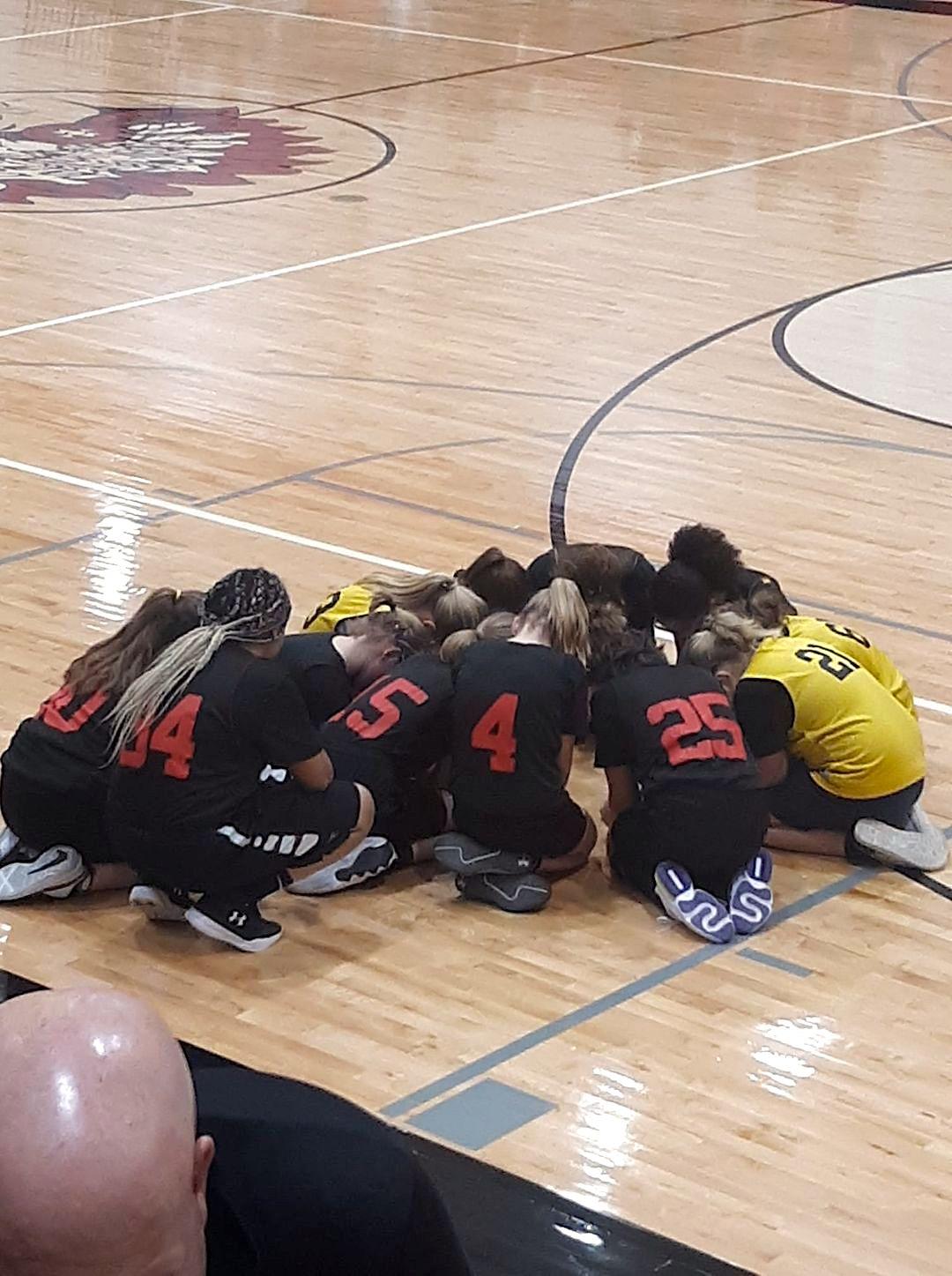 Players of opposing teams caught praying in the middle of the gym. (Courtesy of <a href="https://www.facebook.com/staci.cromer">Staci Cromer</a>)