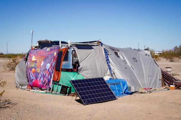 A large tent complete with solar panel sits on Bureau of Land Management land at the La Posa South Long-Term Visitor Site in Quartzsite, Ariz., on Feb. 12, 2022.  (Allan Stein/The Epoch Times)