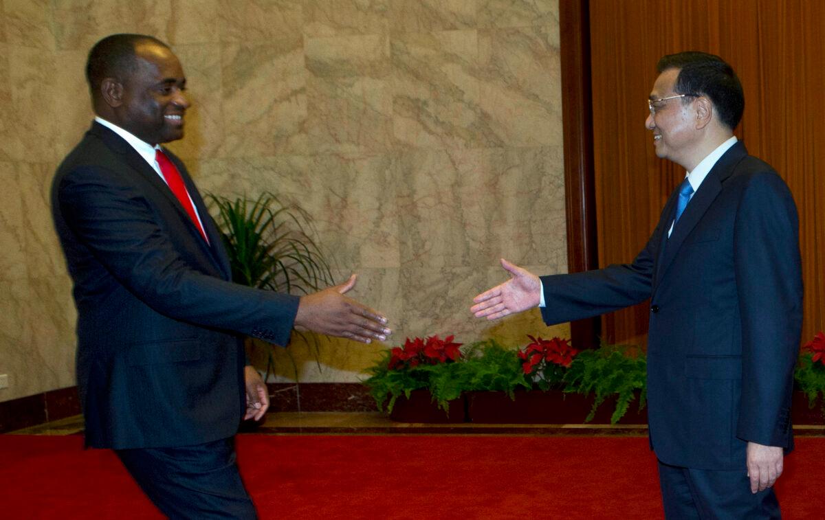  Dominica Prime Minister Roosevelt Skerrit shakes hands with Chinese Premier Li Keqiang during a meeting at the Great Hall of the People in Beijing on July 17, 2013. (Ng Han Guan/AFP via Getty Images)