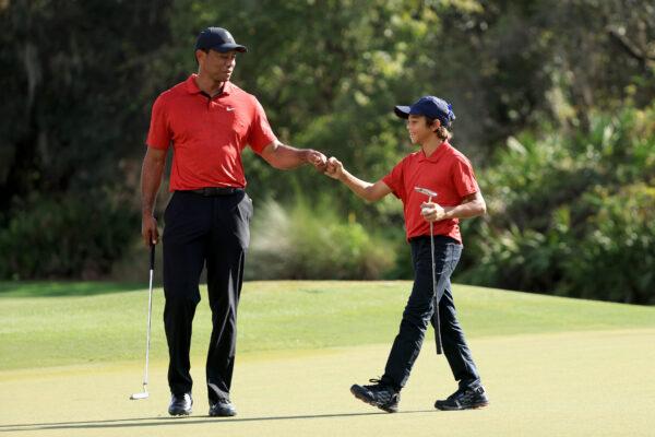 Tiger Woods and Charlie Woods celebrate a birdie on the 12th hole during the final round of the PNC Championship at the Ritz Carlton Golf Club Grande Lakes, in Orlando, on Dec. 19, 2021. (Sam Greenwood/Getty Images)