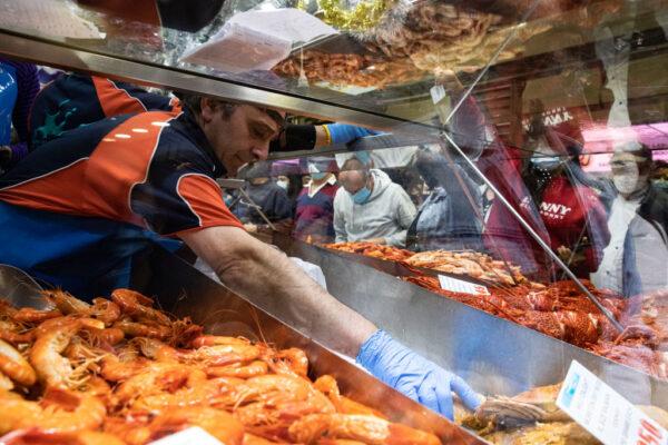 A fish market worker grabs some crustaceous for a client ahead of Christmas Day at Queen Victoria Market in Melbourne, Australia, on Dec. 24, 2021. (Diego Fedele/Getty Images)