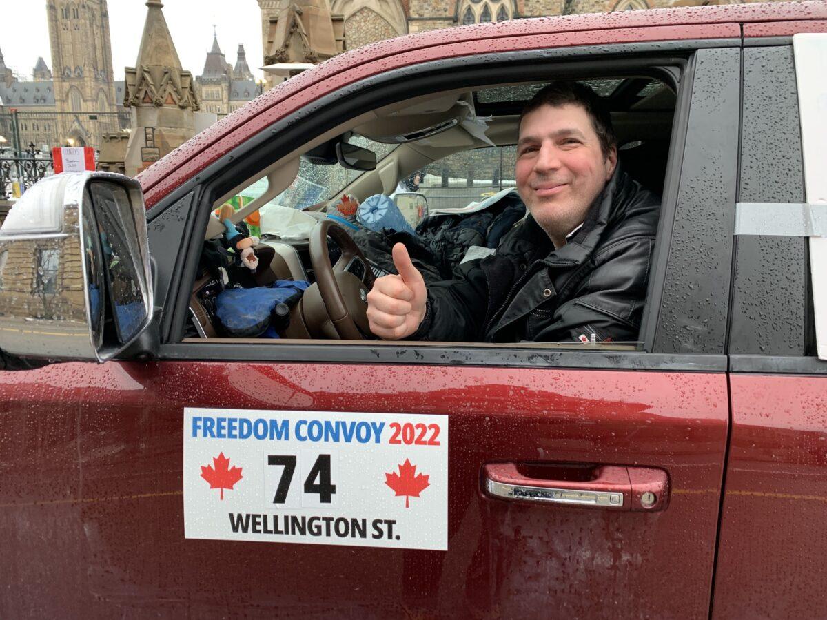 A protester gives a thumbs-up as he demonstrates against COVID-19 mandates and restrictions in Ottawa on Feb. 17, 2022. (Jonathan Ren/The Epoch Times)