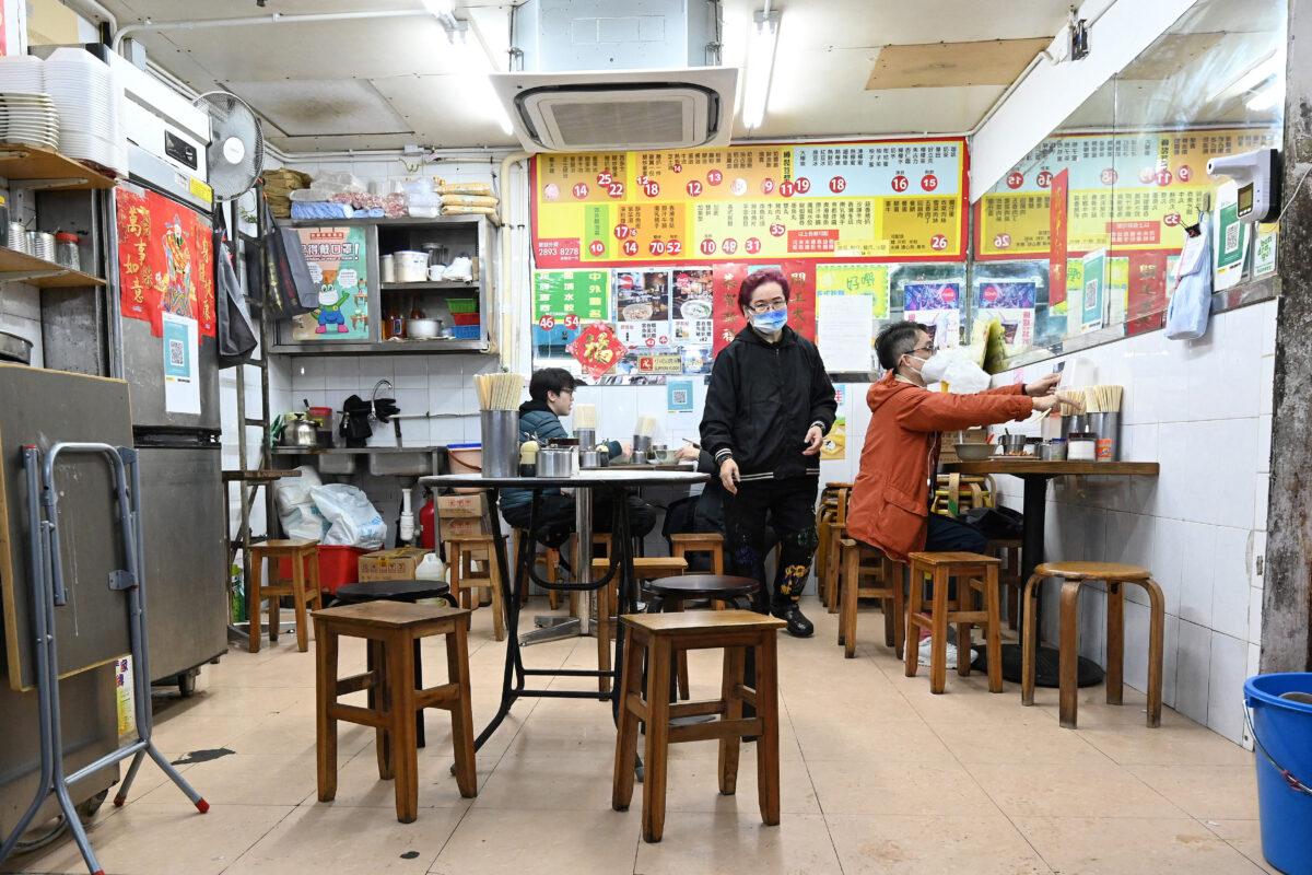 People eat at a small restaurant in Hong Kong on Feb. 17, 2022. (Peter Parks/AFP via Getty Images)