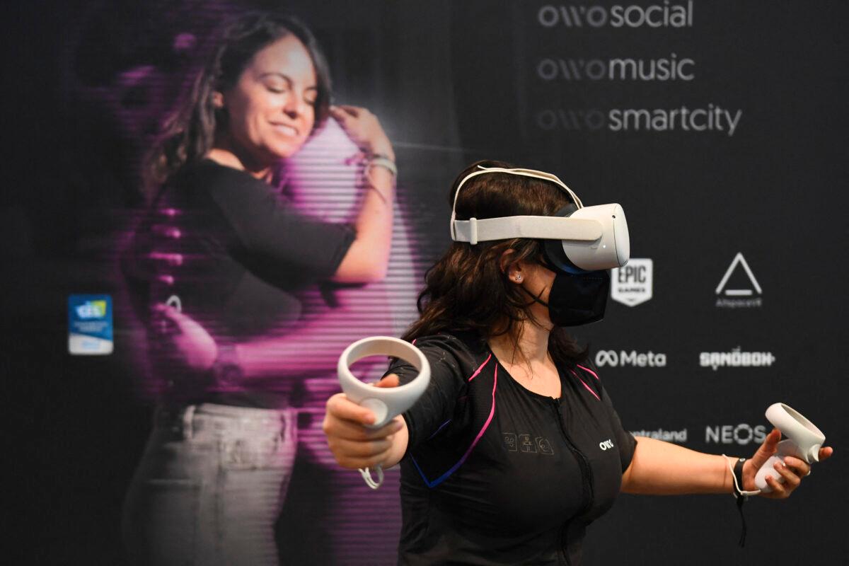 An attendee demonstrates the Owo vest, which allows users to feel physical sensations during metaverse experiences such as virtual reality games, including wind, gunfire, or punching, at the Consumer Electronics Show (CES), in Las Vegas, on Jan. 5, 2022. (Patrick T. Fallon/AFP via Getty Images)