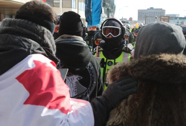 An in-your-face confrontation between protesters and police in Ottawa on Feb. 18, 2022. (Richard Moore/The Epoch Times)