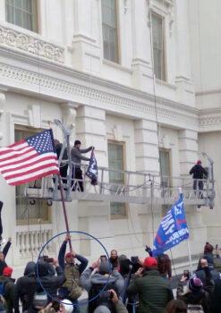 Robert Schornak used a stolen flag from the U.S. Capitol to rally rioters on Jan. 6, 2021, prosecutors alleged. (U.S. Department of Justice)