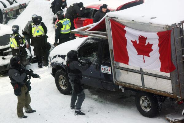 A police officer smashes a truck window as police deploy to remove demonstrators participating in the Freedom Convoy protest opposing COVID-19 mandates and restriction, in Ottawa on Feb. 19, 2022. (Dave Chan/AFP via Getty Images)