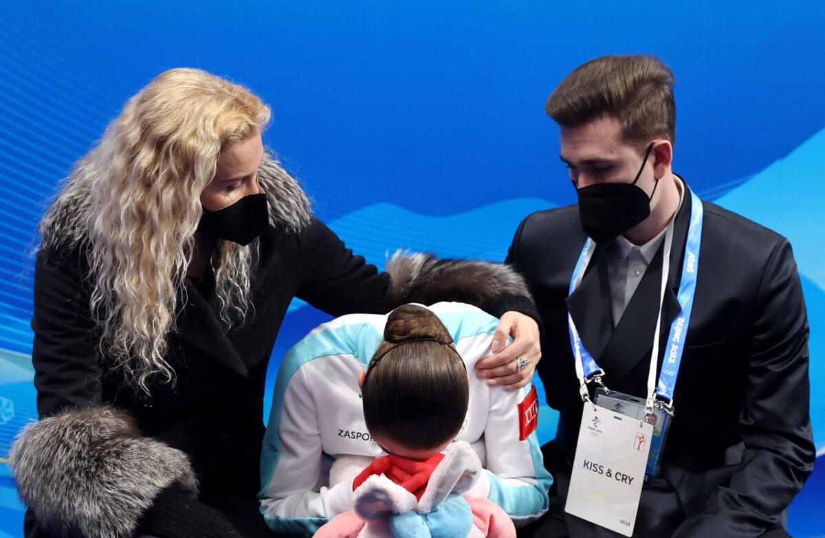Kamila Valieva of the Russian Olympic Committee (C) reacts to her score with choreographer Daniil Gleikhengauz (R) and coach Eteri Tutberidze (L) after the Women's Single Skating Free Skating on day thirteen of the Beijing 2022 Winter Olympic Games at Capital Indoor Stadium in Beijing on Feb. 17, 2022. (Matthew Stockman/Getty Images)