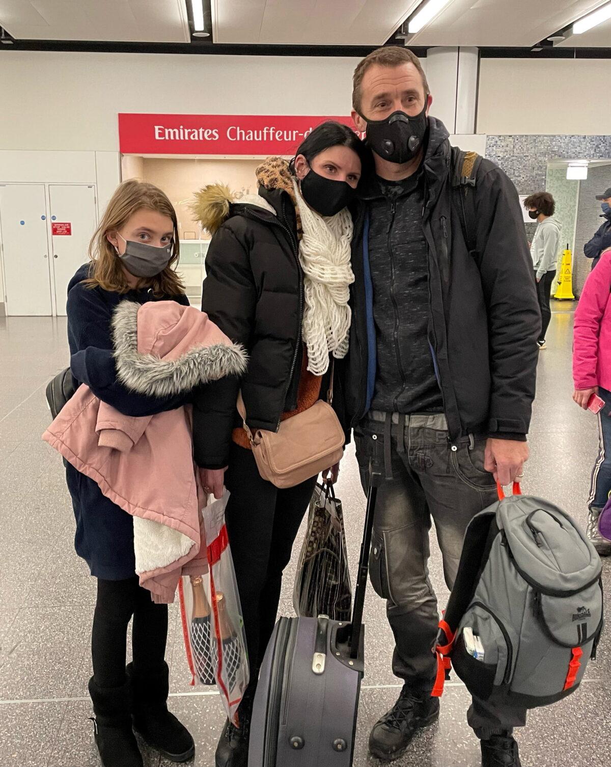 Paul Meakin, his wife Svetlana, and their daughter arrive at the Gatwick airport in London from Kyiv, Ukraine, on Feb. 12, 2022. (Sophie Wingate/PA)
