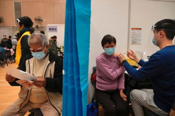 A woman receives a dose of China's Sinovac COVID-19 coronavirus vaccine at a community vaccination center in Hong Kong, Feb. 25, 2022. (Kin Cheung/AP Photo)